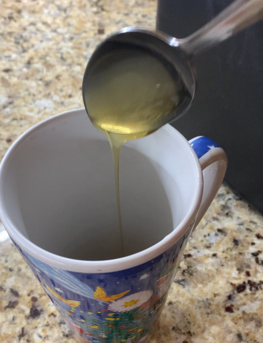 pouring honey into a coffee mug