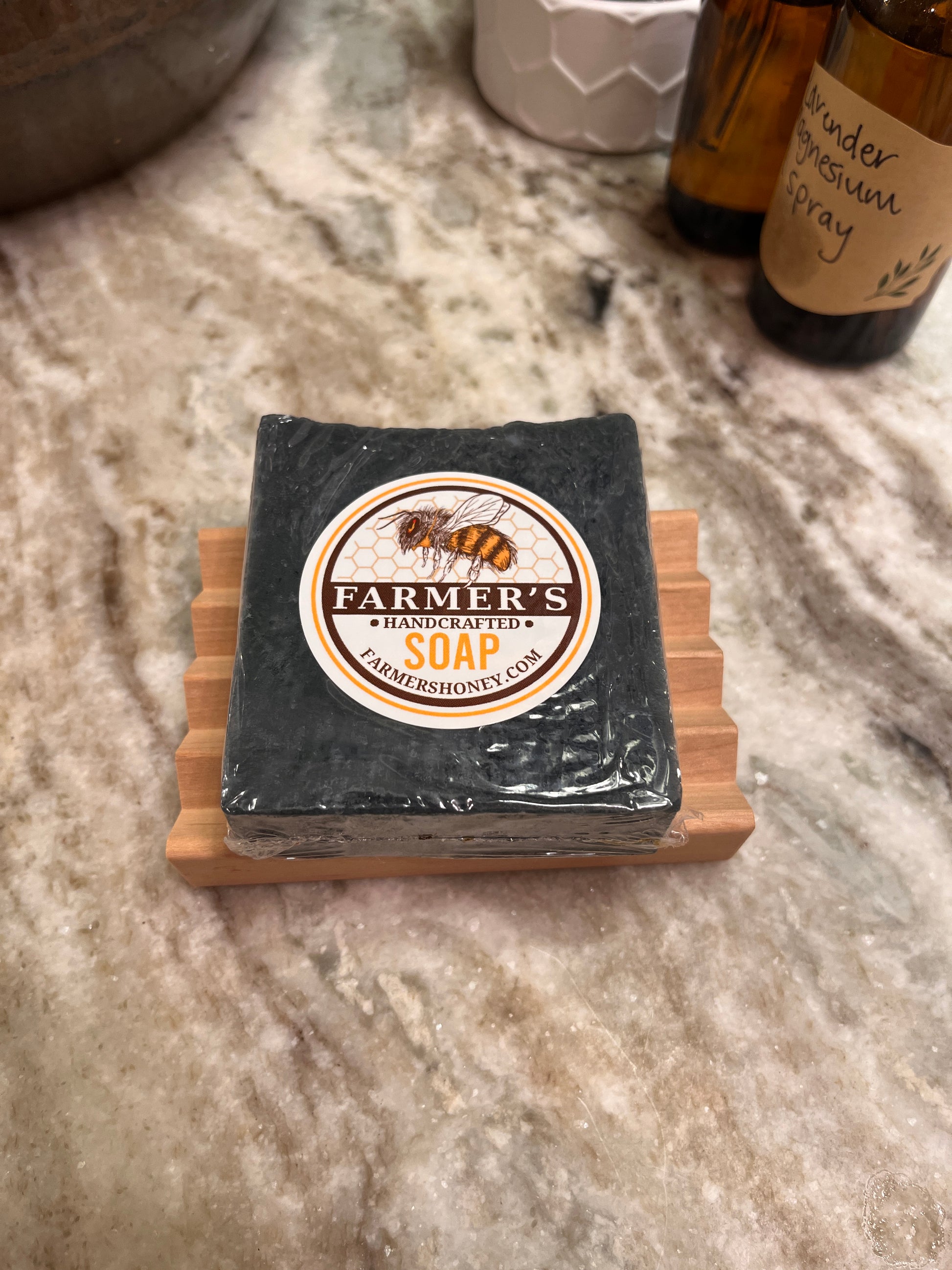 black soap resting on a soap saver near some spray