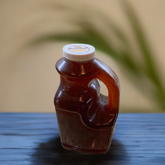 raw unfiltered honey by gallon on a table with green plant